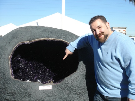 Jasun pointing to Calcite in large Amethyst Geode in front of the Inn Suites